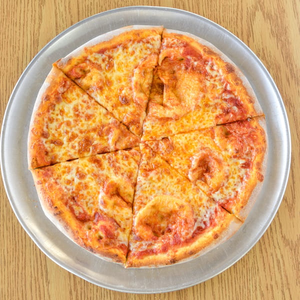 A whole cheese pizza, cut into eight slices, on a metal tray on a wooden table.